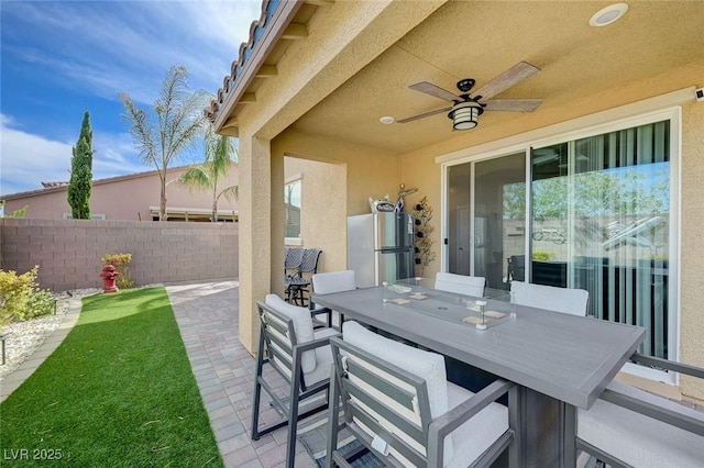 view of patio / terrace with fence, ceiling fan, and outdoor dining space