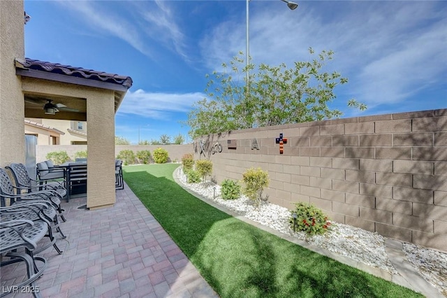 view of yard with a patio area, a fenced backyard, a ceiling fan, and outdoor dining area