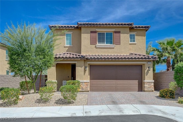 mediterranean / spanish-style house with a garage, a tile roof, and stucco siding