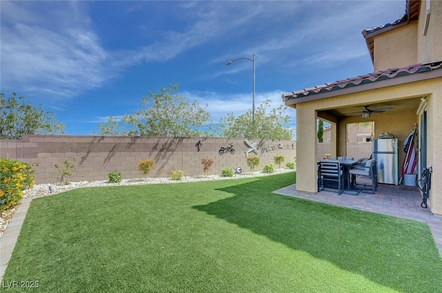 view of yard with a fenced backyard, a ceiling fan, and a patio