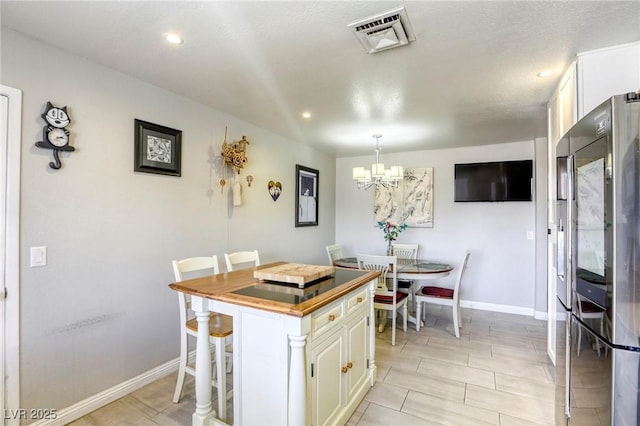 kitchen featuring a chandelier, visible vents, white cabinets, and stainless steel fridge with ice dispenser