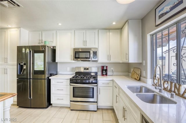 kitchen with a sink, visible vents, recessed lighting, white cabinetry, and appliances with stainless steel finishes