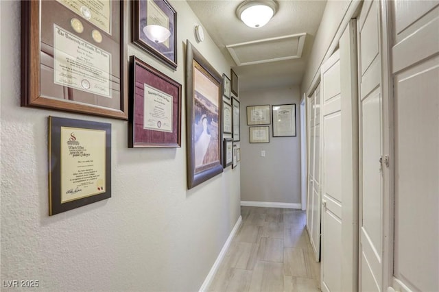 hall with attic access and baseboards