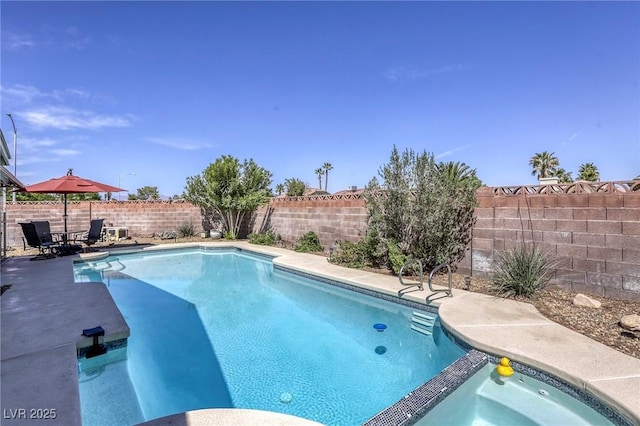 view of pool featuring a fenced backyard, a pool with connected hot tub, and a patio