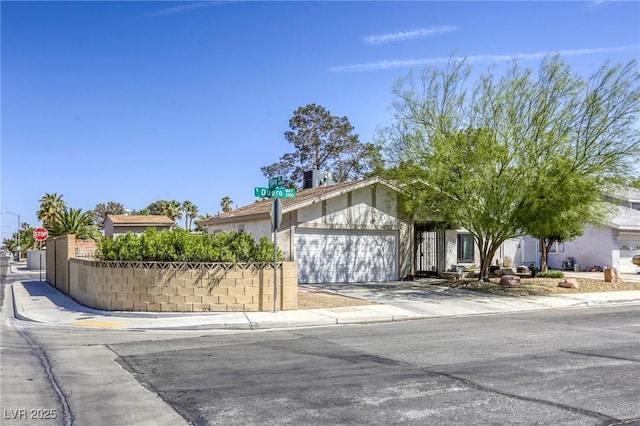 view of front of home with a chimney, fence, concrete driveway, stucco siding, and a garage