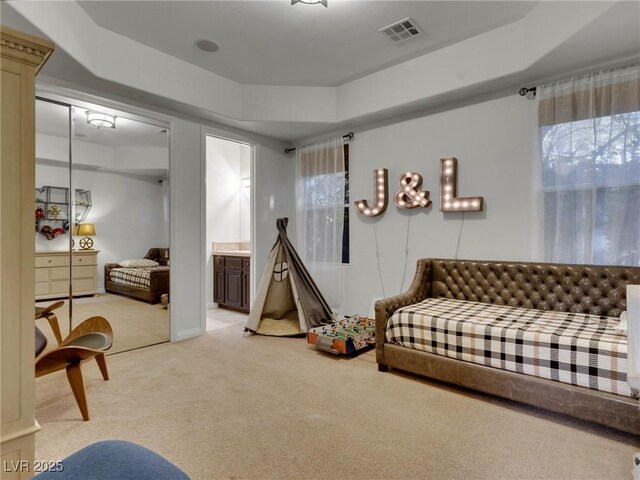 interior space featuring light carpet, ensuite bathroom, and visible vents