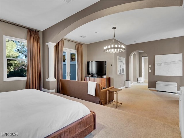bedroom with ornate columns, arched walkways, carpet floors, baseboards, and a chandelier