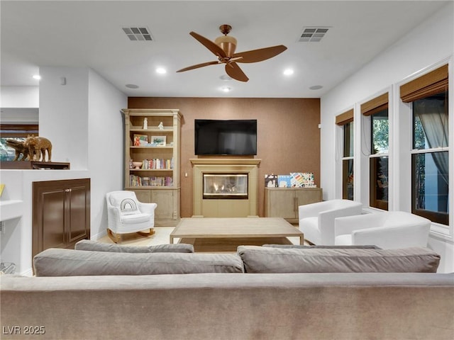 living room featuring a ceiling fan, visible vents, and recessed lighting