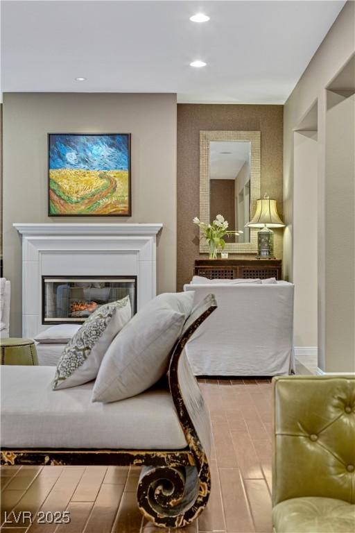 bedroom featuring recessed lighting and a glass covered fireplace