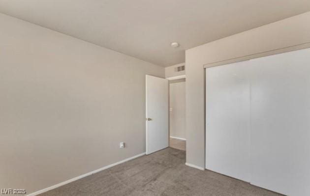 unfurnished bedroom featuring baseboards, a closet, and carpet