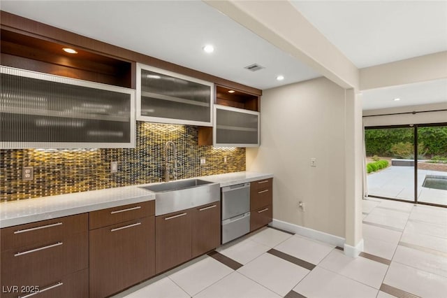 bar with visible vents, stainless steel dishwasher, a sink, baseboards, and tasteful backsplash