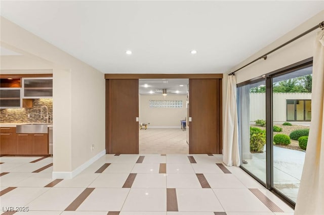 hall with recessed lighting, light carpet, a sink, light tile patterned flooring, and baseboards