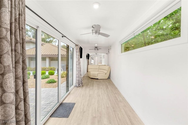 corridor featuring baseboards and light wood-style floors