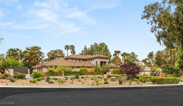 exterior space featuring a tile roof, a chimney, and stucco siding