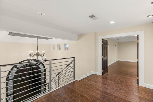 hall featuring recessed lighting, wood finished floors, visible vents, an upstairs landing, and a notable chandelier