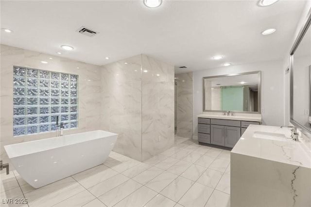 full bath featuring recessed lighting, a freestanding tub, visible vents, and a walk in shower