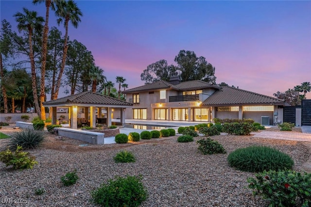 back of property featuring a gazebo, a tiled roof, and stucco siding