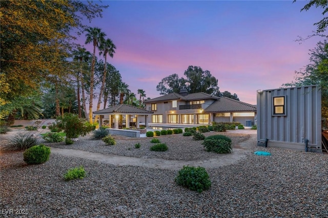 back of house at dusk with a gazebo