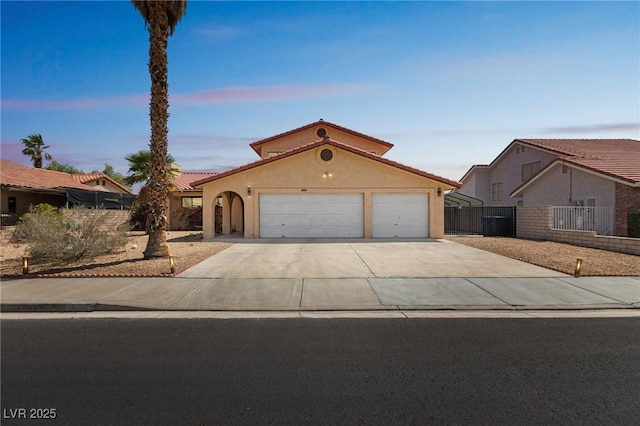 2111 River City Dr, Laughlin, NV 89029 - mediterranean / spanish home featuring a garage, driveway, stucco siding, fence, and a tiled roof