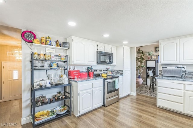 2111 River City Dr, Laughlin, NV 89029 - kitchen featuring stainless steel range with electric stovetop, black microwave, light wood-style floors, white cabinets, and a textured ceiling