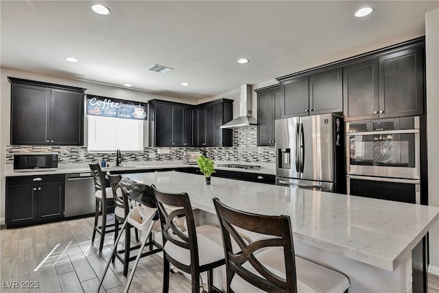 10126 Cliff Dwellings Ave, Las Vegas, NV 89178 - kitchen featuring stainless steel appliances, wall chimney range hood, decorative backsplash, light stone countertops, and a sink
