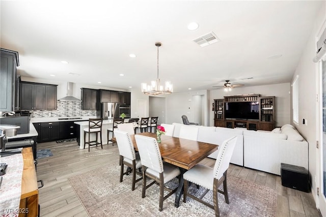 dining room featuring recessed lighting, visible vents, ceiling fan with notable chandelier, and light wood-style floors