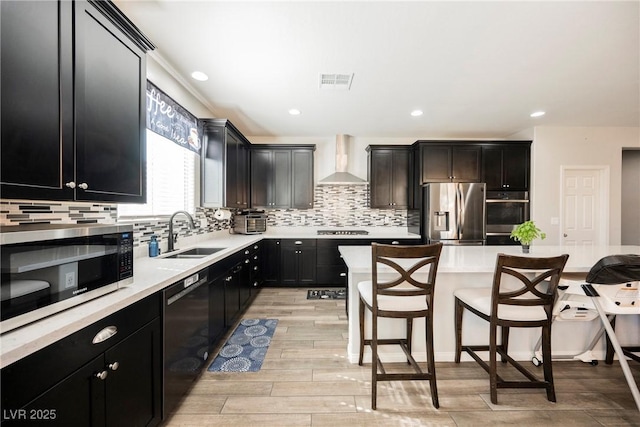 10126 Cliff Dwellings Ave, Las Vegas, NV 89178 - kitchen with stainless steel appliances, a sink, wall chimney range hood, a kitchen breakfast bar, and light countertops