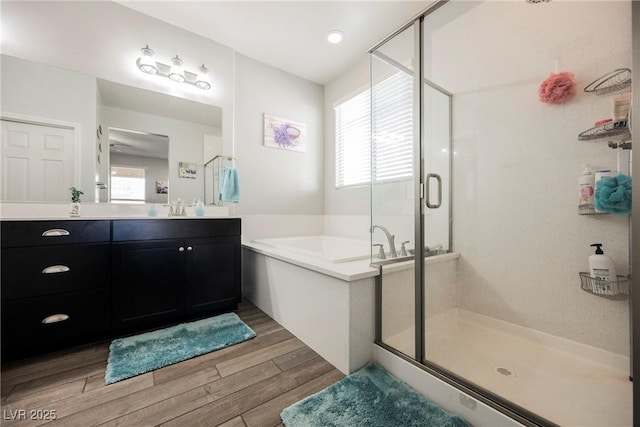 10126 Cliff Dwellings Ave, Las Vegas, NV 89178 - full bathroom featuring a bath, a stall shower, wood finished floors, and vanity