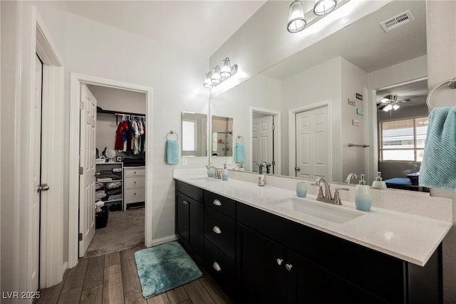 10126 Cliff Dwellings Ave, Las Vegas, NV 89178 - bathroom with double vanity, wood finished floors, a walk in closet, and ensuite bath
