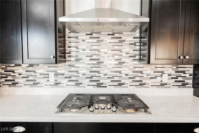 10126 Cliff Dwellings Ave, Las Vegas, NV 89178 - kitchen featuring wall chimney range hood, stainless steel gas cooktop, dark brown cabinets, and decorative backsplash