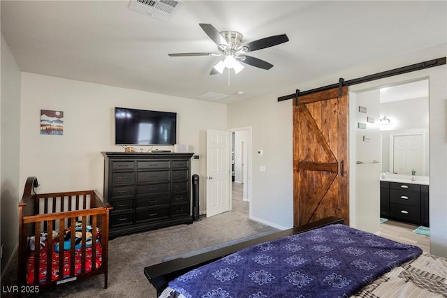 10126 Cliff Dwellings Ave, Las Vegas, NV 89178 - bedroom featuring a barn door, baseboards, ensuite bathroom, ceiling fan, and carpet