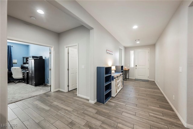 hallway featuring recessed lighting, baseboards, and light wood finished floors