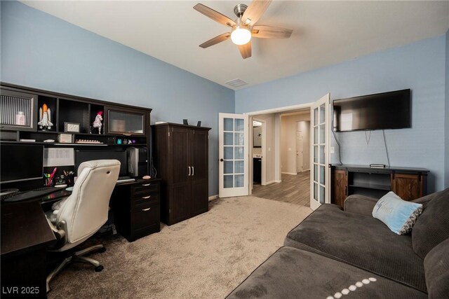 office with visible vents, light carpet, baseboards, french doors, and a ceiling fan