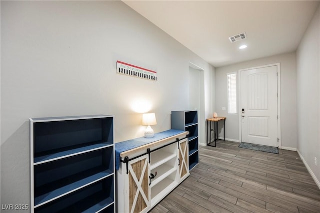 foyer entrance with baseboards, recessed lighting, wood finished floors, and visible vents