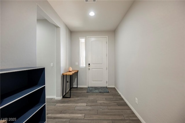 entryway featuring baseboards, visible vents, and wood finished floors