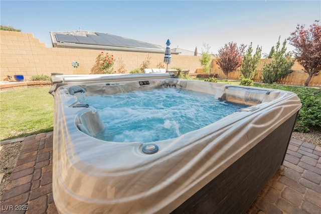 view of pool with a fenced backyard and a hot tub