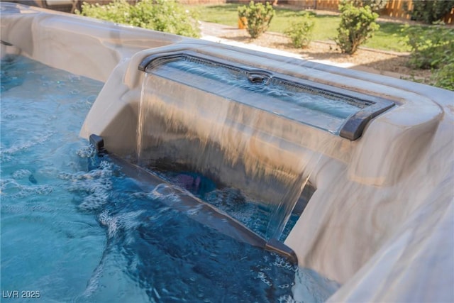 view of swimming pool featuring a hot tub