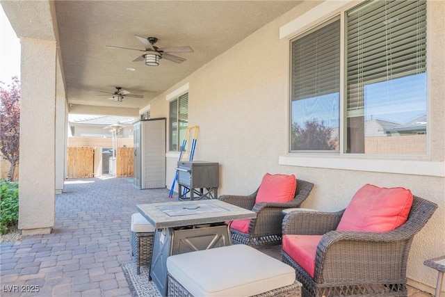 view of patio with ceiling fan and fence