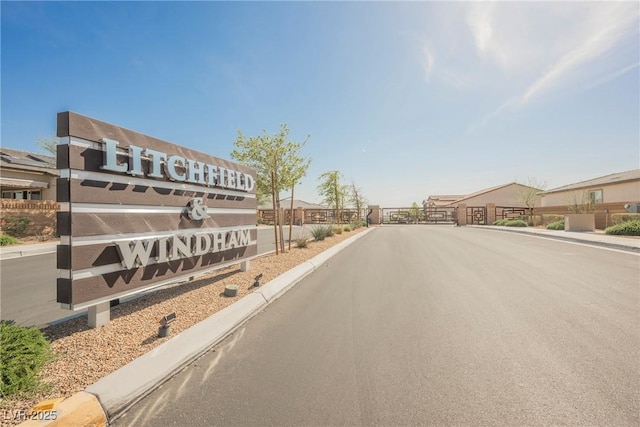 10126 Cliff Dwellings Ave, Las Vegas, NV 89178 - view of asphalt road featuring curbs and a gated entry
