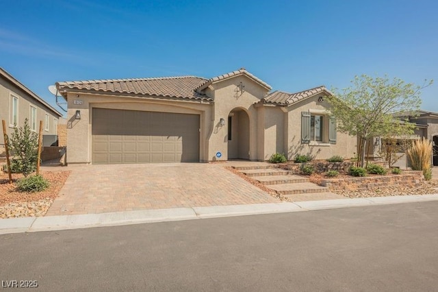 10126 Cliff Dwellings Ave, Las Vegas, NV 89178 - mediterranean / spanish-style home with an attached garage, stucco siding, decorative driveway, and a tiled roof
