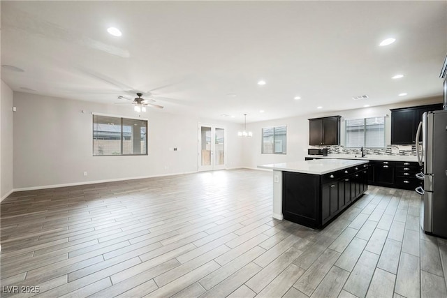 10126 Cliff Dwellings Ave, Las Vegas, NV 89178 - kitchen with freestanding refrigerator, a center island, open floor plan, light countertops, and a ceiling fan