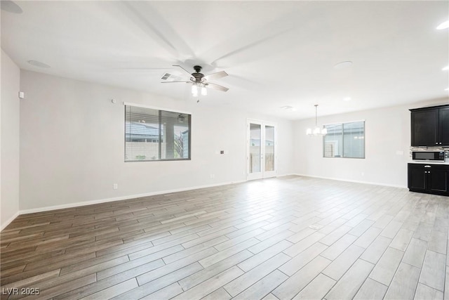 10126 Cliff Dwellings Ave, Las Vegas, NV 89178 - unfurnished living room with healthy amount of natural light, a chandelier, a ceiling fan, and light wood finished floors