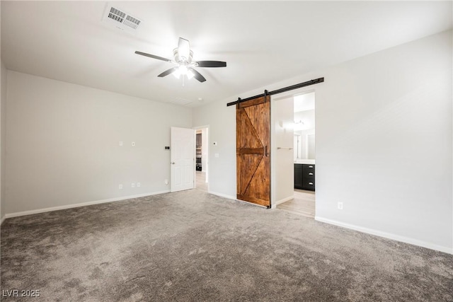 10126 Cliff Dwellings Ave, Las Vegas, NV 89178 - spare room featuring ceiling fan, a barn door, and carpet floors
