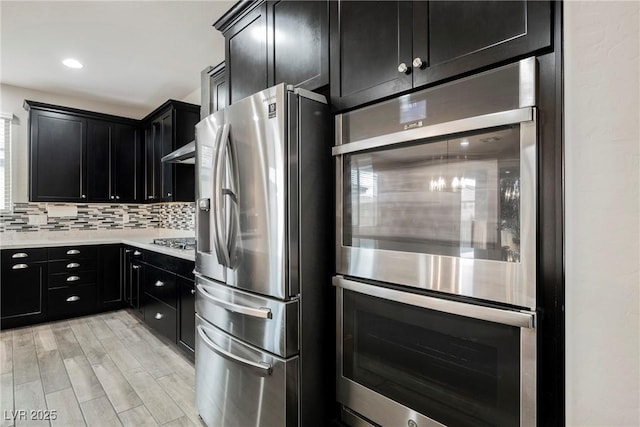 10126 Cliff Dwellings Ave, Las Vegas, NV 89178 - kitchen with appliances with stainless steel finishes, dark cabinets, light countertops, tasteful backsplash, and recessed lighting