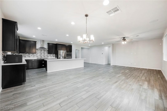 10126 Cliff Dwellings Ave, Las Vegas, NV 89178 - kitchen featuring wall chimney exhaust hood, appliances with stainless steel finishes, ceiling fan, open floor plan, and light countertops