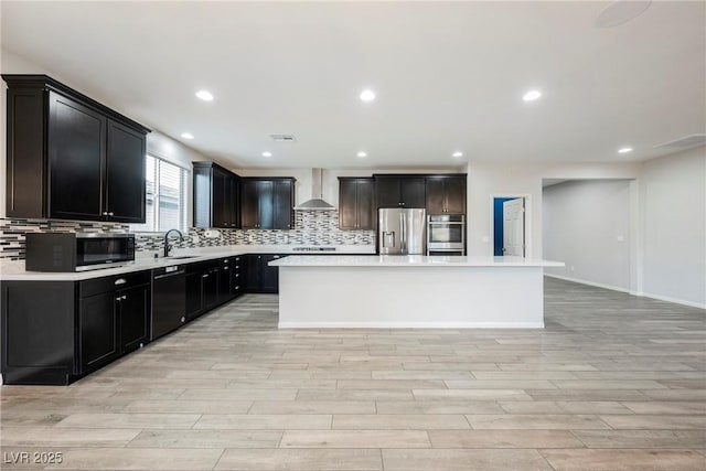 10126 Cliff Dwellings Ave, Las Vegas, NV 89178 - kitchen featuring appliances with stainless steel finishes, light wood-style flooring, wall chimney exhaust hood, light countertops, and recessed lighting