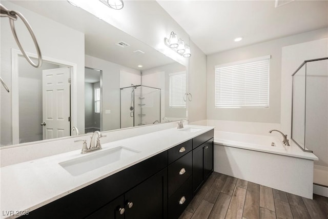 10126 Cliff Dwellings Ave, Las Vegas, NV 89178 - full bath featuring a stall shower, wood finished floors, a bath, double vanity, and recessed lighting