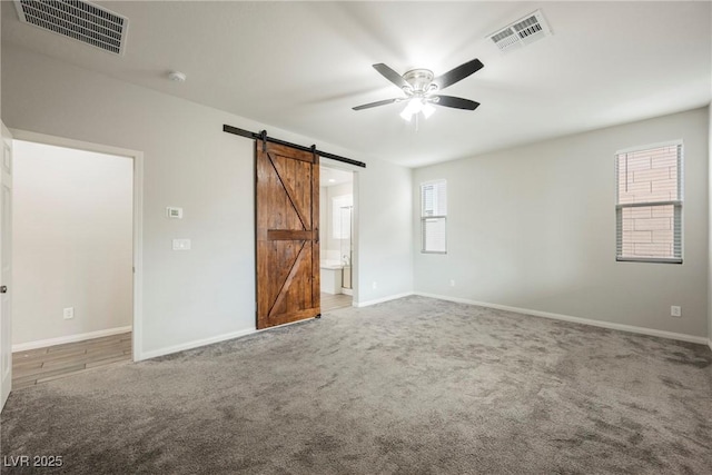 10126 Cliff Dwellings Ave, Las Vegas, NV 89178 - unfurnished bedroom with a barn door, carpet flooring, and connected bathroom