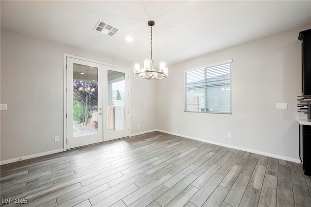 10126 Cliff Dwellings Ave, Las Vegas, NV 89178 - unfurnished dining area with wood finished floors, a chandelier, and french doors