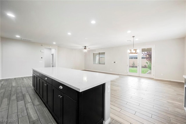 10126 Cliff Dwellings Ave, Las Vegas, NV 89178 - kitchen featuring dark cabinetry, ceiling fan, light wood-style floors, a center island, and recessed lighting